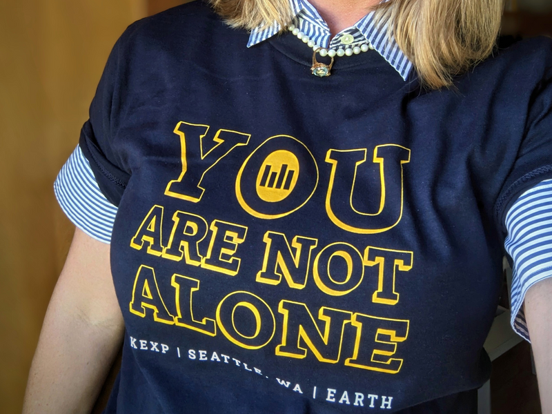 Allusio founder Julie Dusold Culbertson wearing a shirt from Seattle KEXP radio that reads "You are not alone."