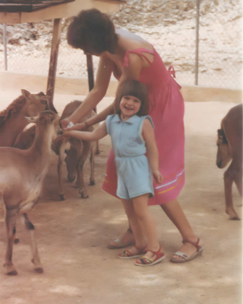 mother and child feeding goats from a bottle